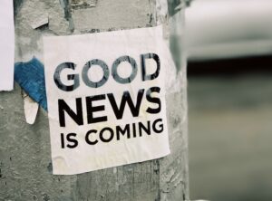 white Good News Is Coming paper on wall